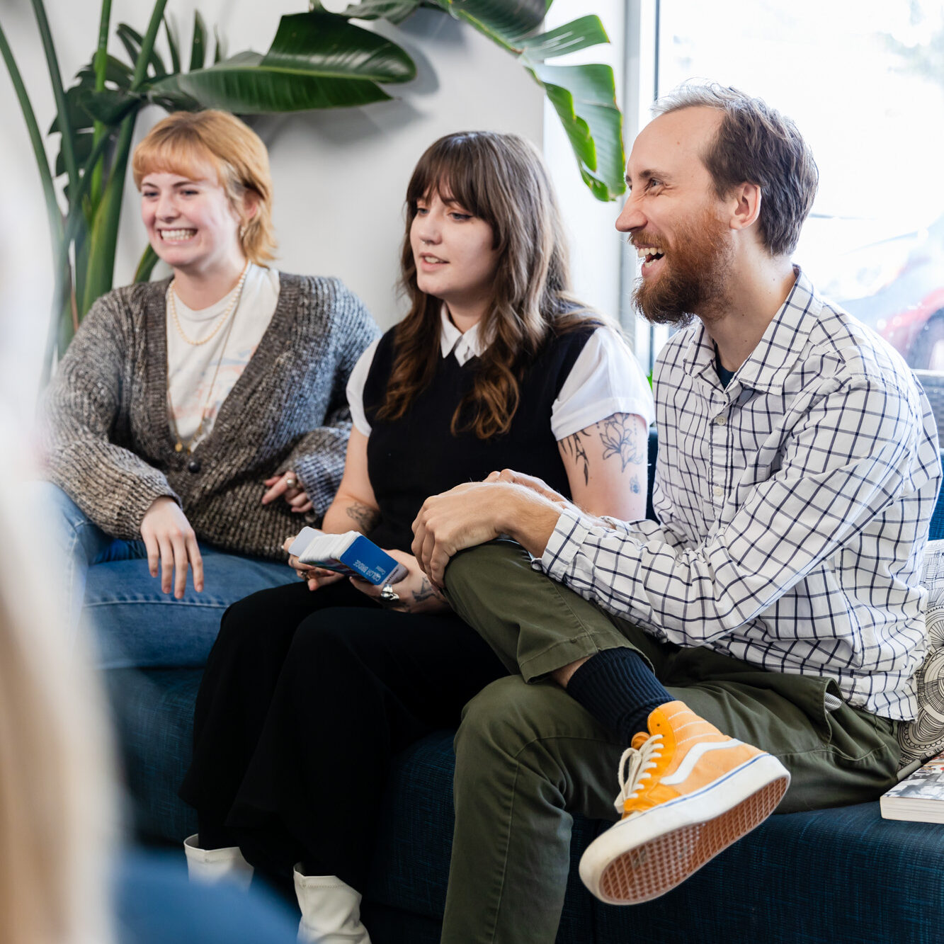 three designers sitting on a couch discussing the difference between SEO vs. Non-SEO pages