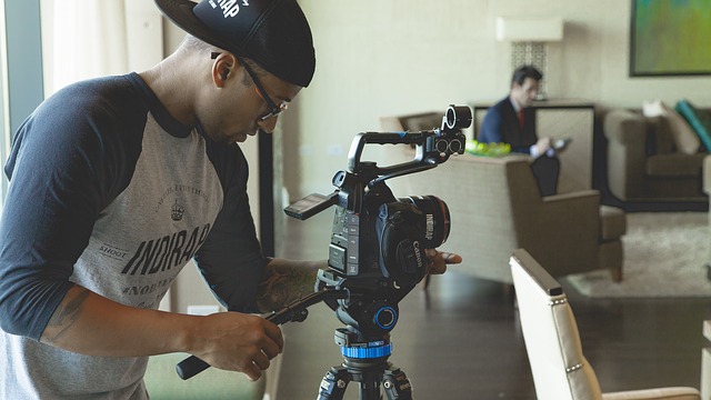 HD video production in Overland Park with a videographer setting up a professional camera for an indoor commercial shoot.