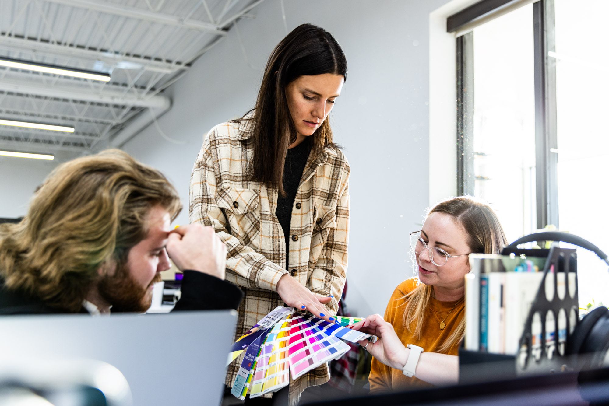 A group of Lifted Logic employees looks at color swatch cards for their digital design.