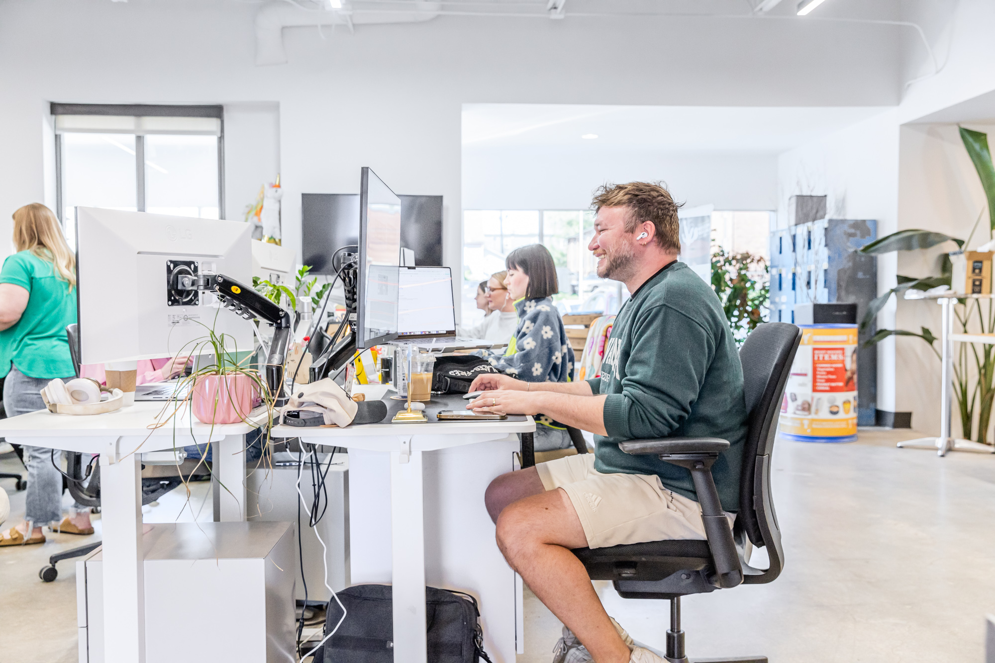 a writer smiles at his desk while writing content on a computer for architecture company websites