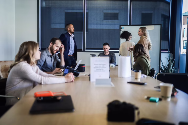 Leadership team around a meeting table working to answer the question: "Do I need a fractional CMO?".