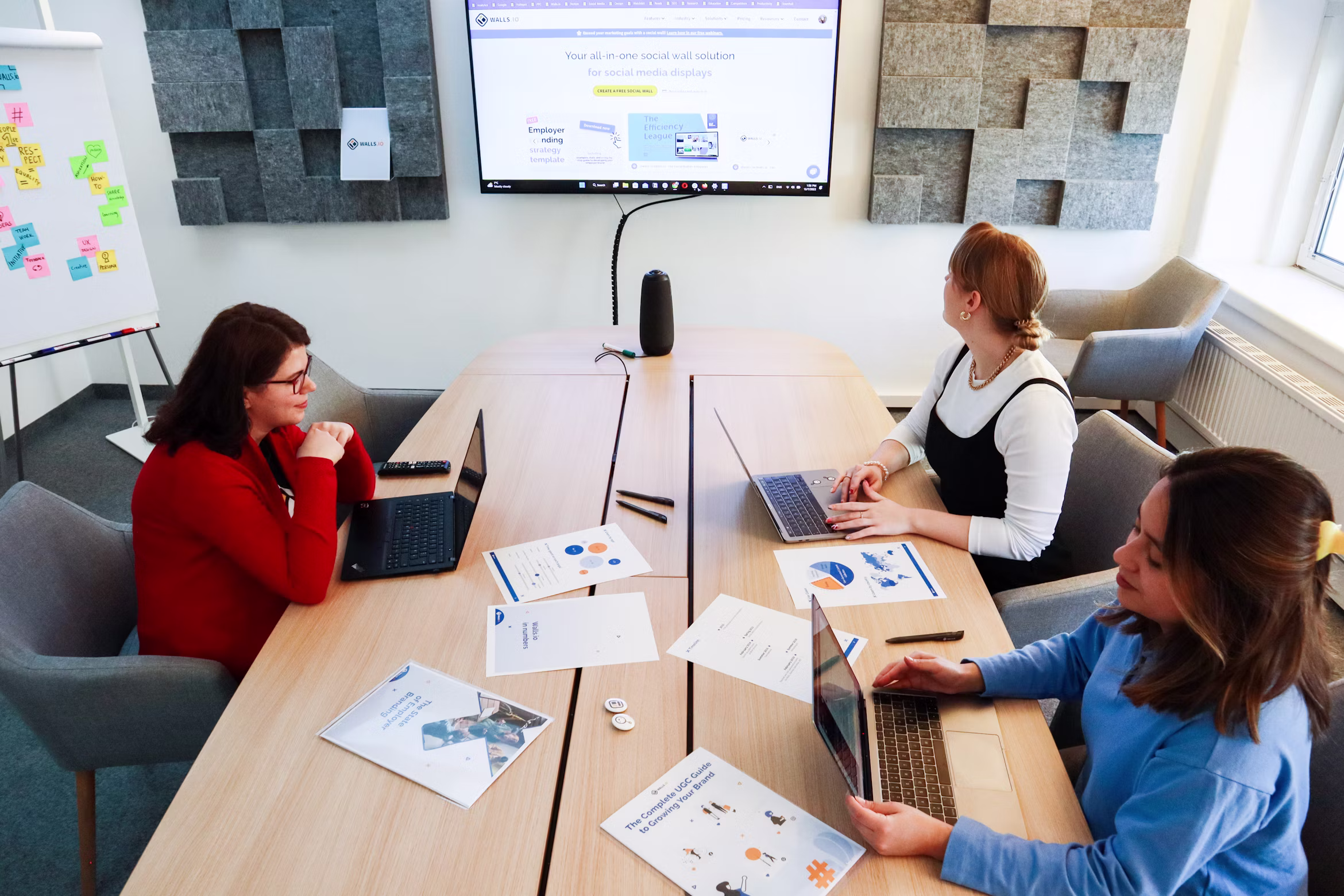 Three women sitting around a table deciding to hire a Fractional CMO vs a Marketing Agency.