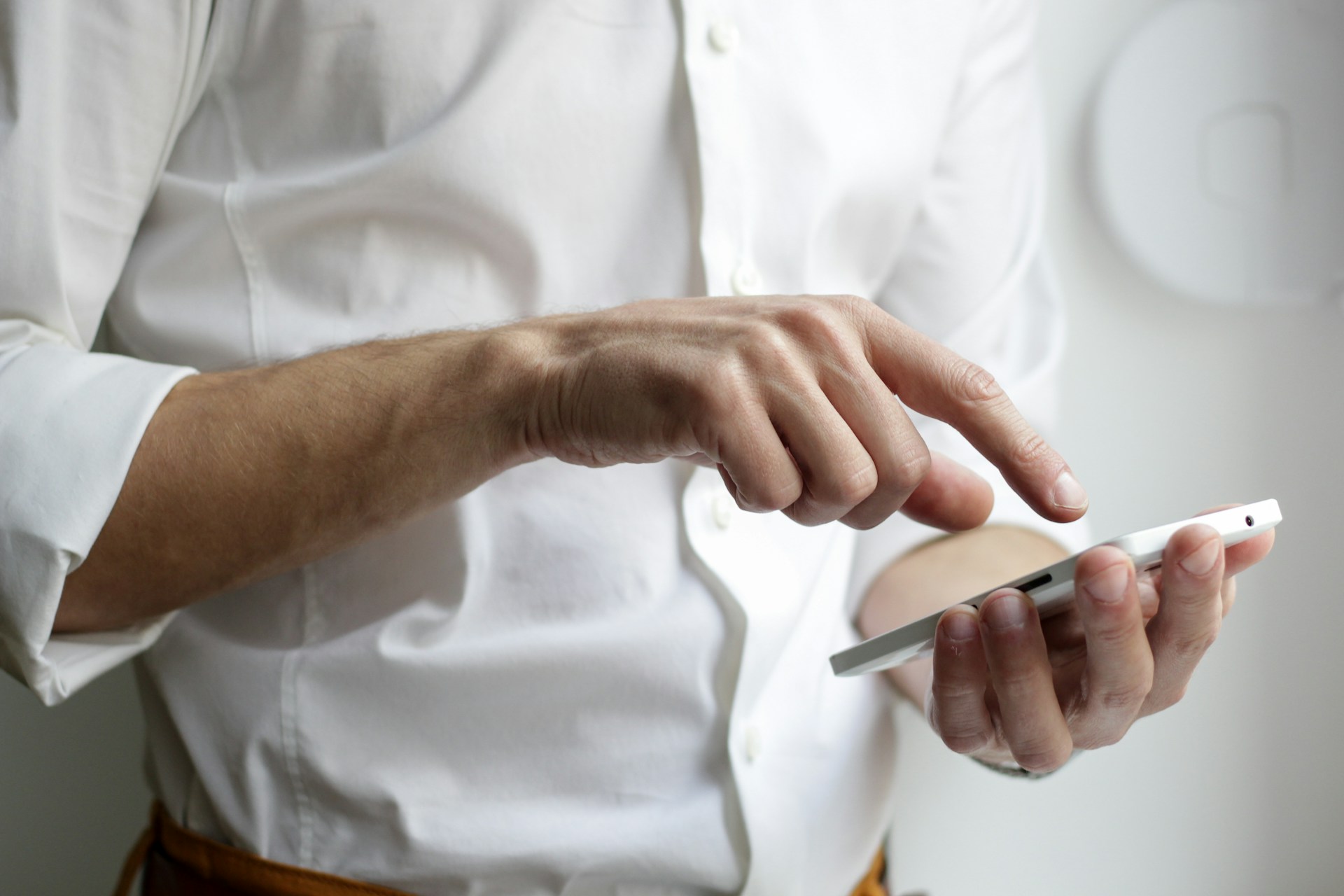 A man types on his phone, a device Kansas City businesses should take into consideration when building out their site and honing SEO.